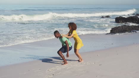 african american man carrying his wife on his back seaside