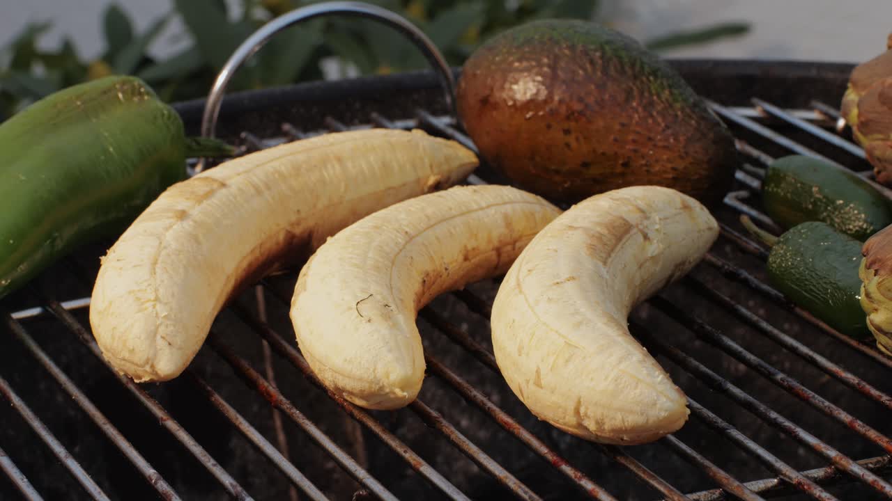 Grilled Banana on fire, latin american vegan grill with avocado and pepper, thai or Ecuadorian Street food. African traditional food on grill.