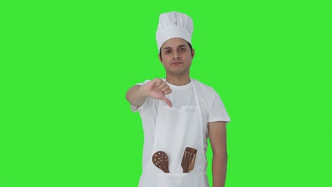 cocinero profesional indio decepcionado mostrando los pulgares hacia abajo pantalla verde