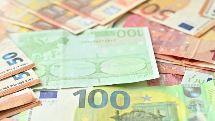 Nahaufnahme von mehreren Fünfzig- und Hundert-Euro-Scheinen, die auf einer Oberfläche verstreut sind