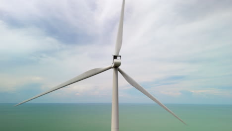 Turbina-Eólica-De-Energía-Limpia-En-Movimiento,-Palas-De-Turbina-Contra-El-Cielo,-Océano-Costero-En-Alta-Mar