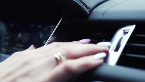 woman's hands operating a car dashboard