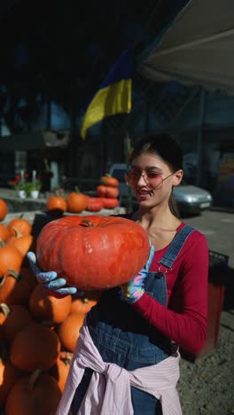 woman buying a pumpkin at a fall market