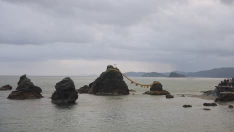 meoto iwa rocks tilt reveal with rain storm in background