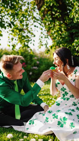 couple celebrating st. patrick's day in a park with a cupcake