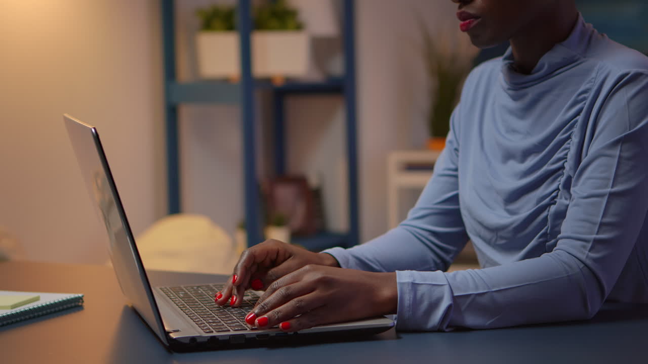 Busy black employee typing on computer sitting on chair