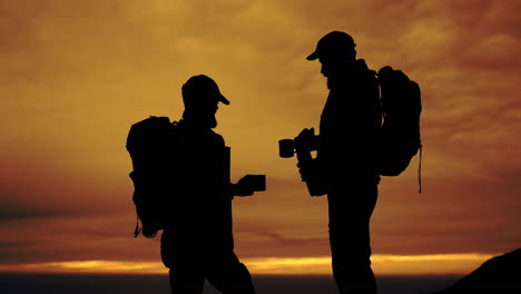 backpackers silhouetted against a sunset