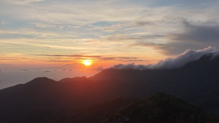 Puesta de sol majestuosa sobre una cordillera con cielo dorado
