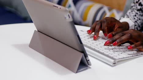 Mid-section-of-female-executive-typing-on-keyboard-at-desk