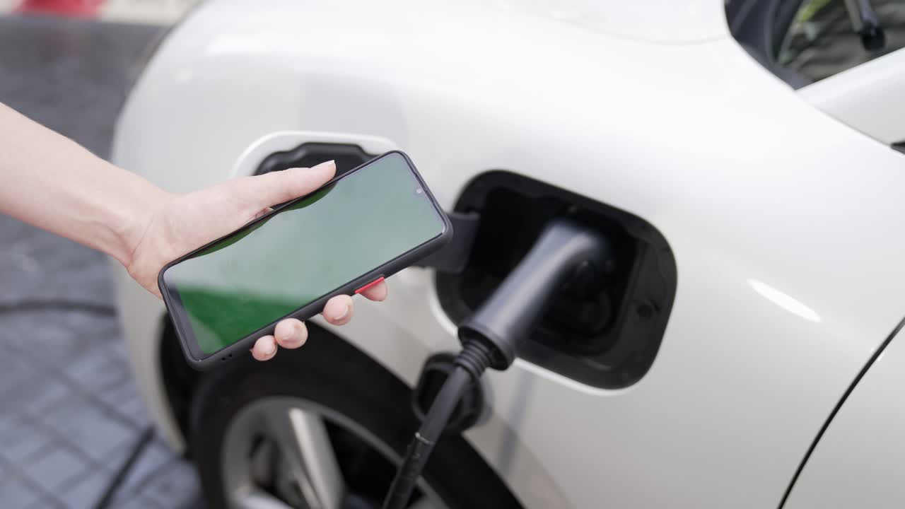 Yeşil ekranlı maket telefon, elektrikli araç ve şarj istasyonunun ilerici konsepti