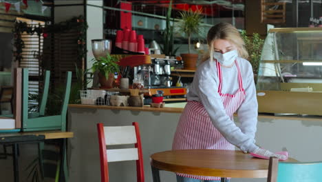 trabajador de un restaurante limpiando mesas durante la pandemia de covid-19