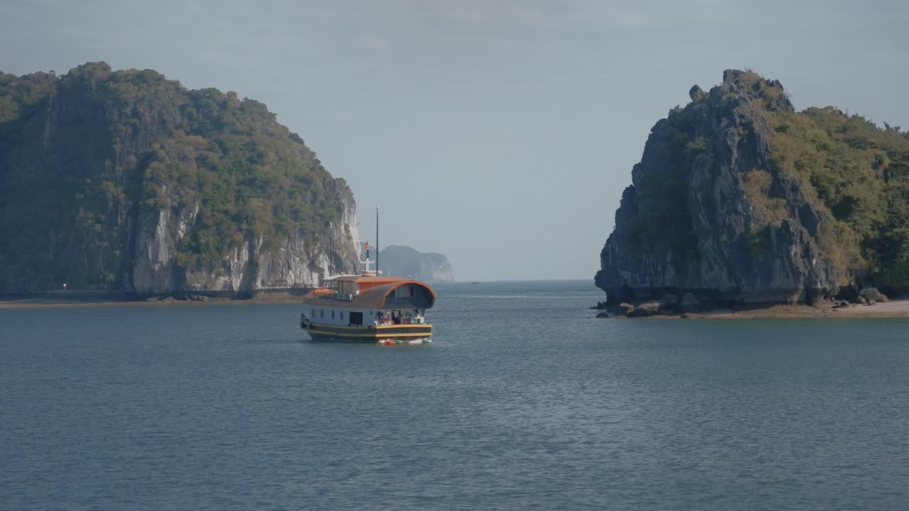 베트남의 카트바 섬과 티르코이즈 물 근처의 만에서 항해하는 배의 파랄락스 드론 뷰