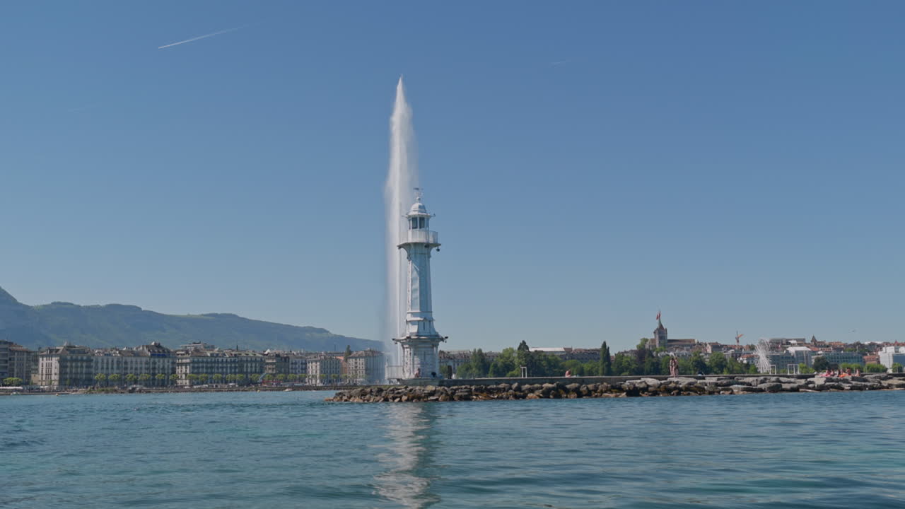 Peaceful morning in Geneva with the iconic Jet d’Eau rising from the lake, calm waters reflecting the clear sky, and the city slowly coming to life in the morning light.