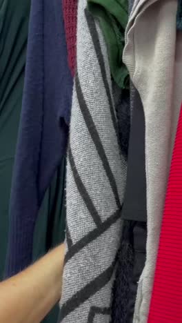 closeup of a woman inspecting secondhand clothes buying used clothes closeup of a woman inspecting secondhand clothes buying used clothes
