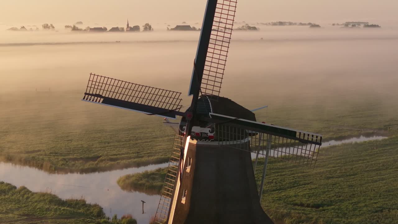 Luftaufnahme einer Windmühlen-Silhouette im nebligen Morgenlicht von Wergea
