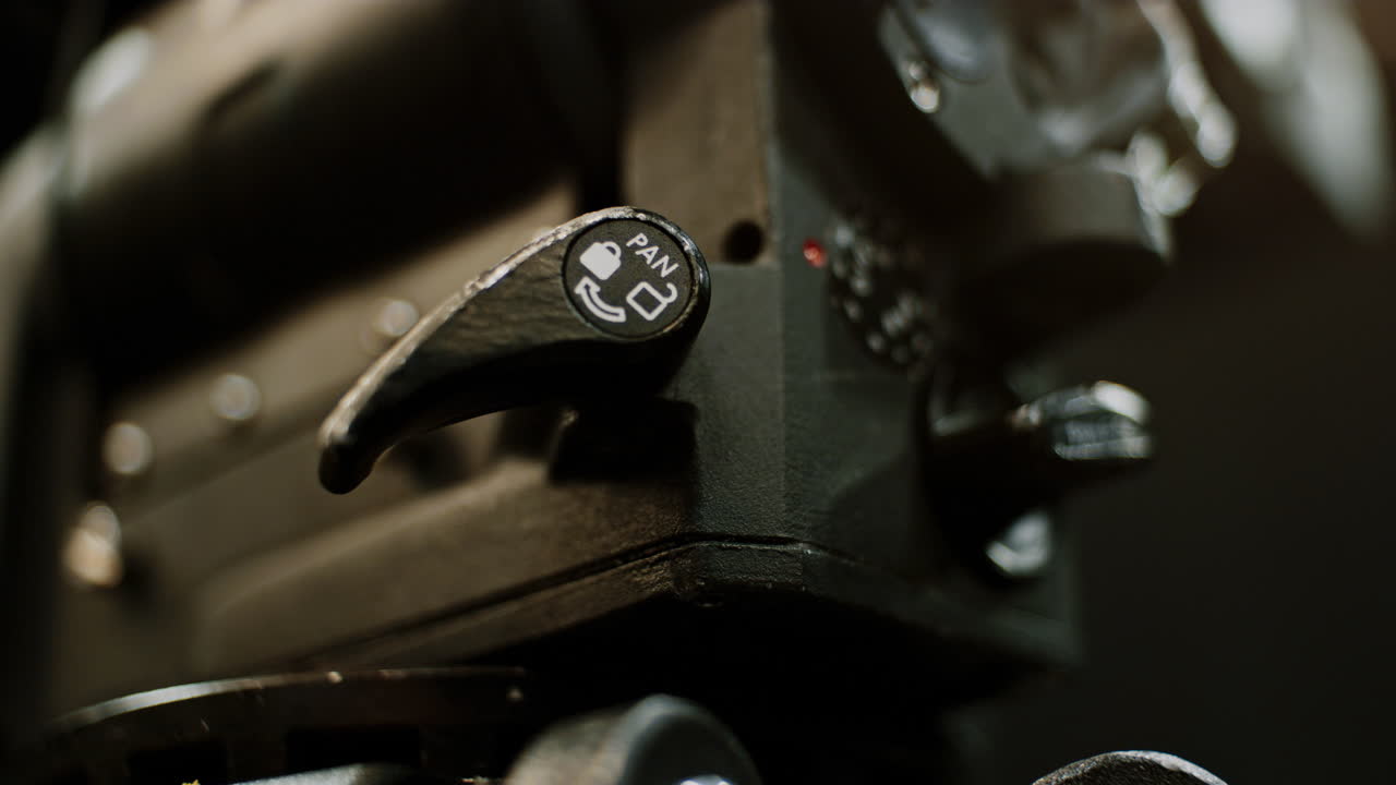 el bloqueo de la bandeja de un trípode de cine profesional de alta gama se está ajustando, primero se bloquea y luego se abre