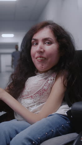 woman in wheelchair in hospital corridor
