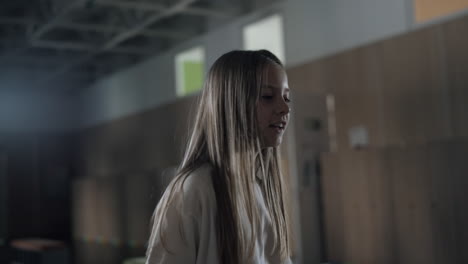 Cute-pupil-girl-jumping-in-school-hallway-close-up.-Playful-teenager-have-fun.