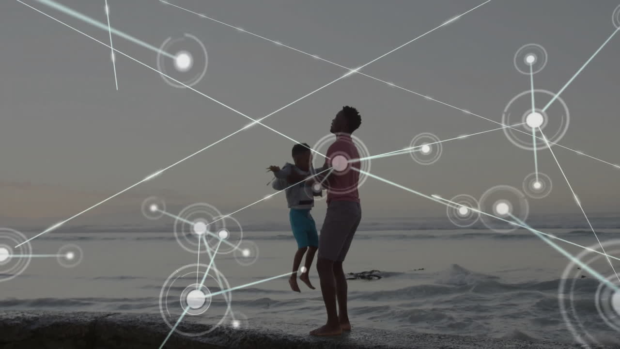 Father and child walking on beach with network connections animation overlay