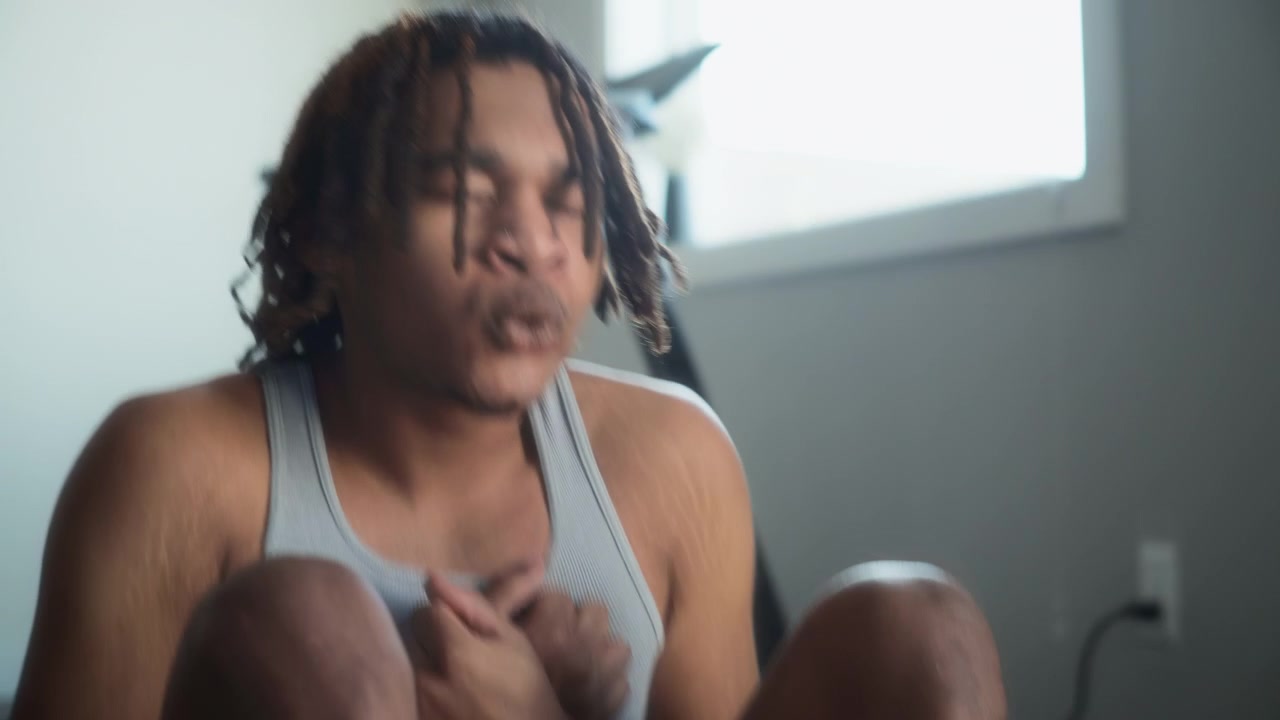 Athletic young man with dreadlocks exercising at home, doing sit-ups
