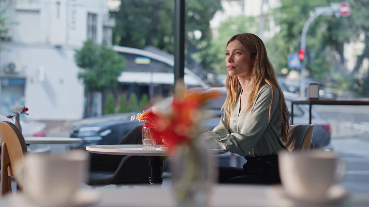 Pensive lady waiting date in modern restaurant looking on smartphone watch