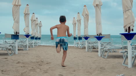 active teen boy running at seaside. carefree guy enjoying summer vacation