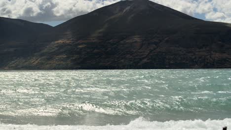 Zerklüftetes-Bergiges-Ufer-Des-Lake-Ohau-An-Einem-Stürmischen,-Aber-Sonnigen-Tag