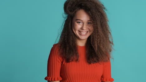 caucasian curly haired woman pointing to the camera and nodding.