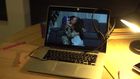 military man with daughter hugging, video on laptop