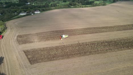 drone shot of a combine harvester at work in a large field