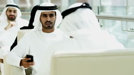 gente de negocios árabe vestido nacional usando teléfono inteligente