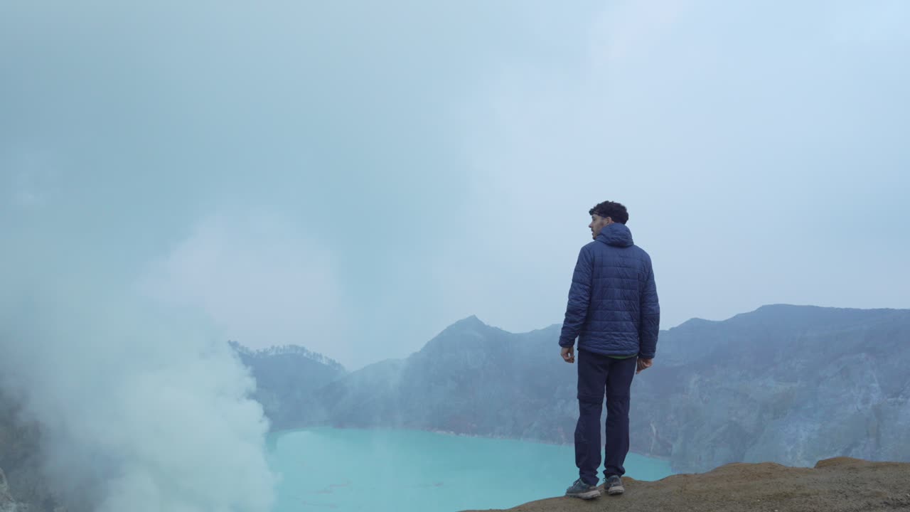 Tourist visiting Kawah Ijen acidic lake active volcanic crater water Java Island Indonesia