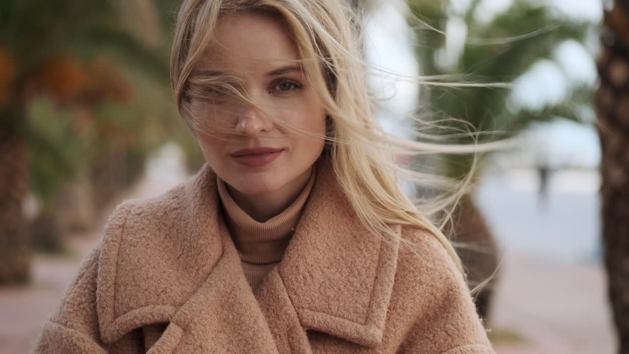 молодая женщина смотрит на камеру на открытом воздухе.