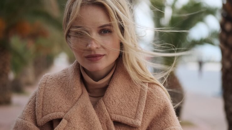 une jeune femme regardant la caméra à l'extérieur.