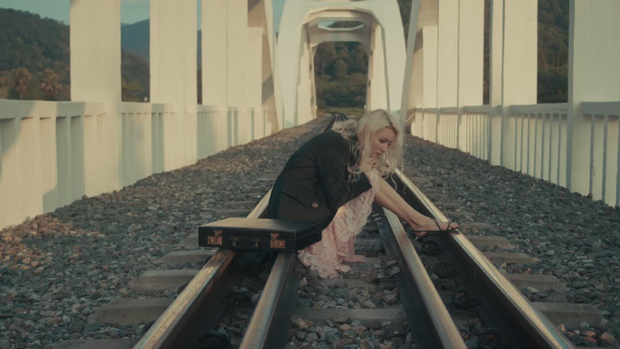 Woman sitting alone on train tracks