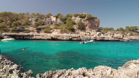 Spain-Mallorca-Cala-Llombards-and-Cala-Santanyi-at-4k-24fps-with-ND-filters-flying-with-a-DJI-Mavic-Air-with-beautiful-views-of-the-beaches,-rocks,-boats-and-blue-water