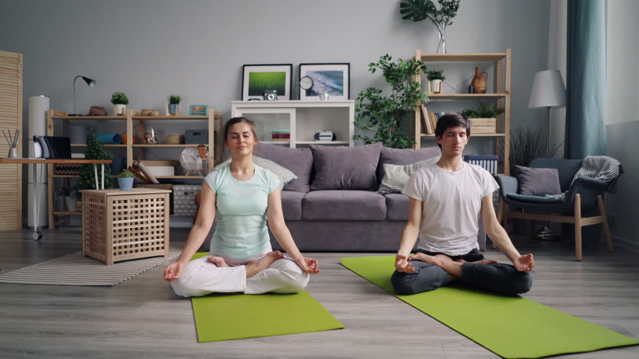 pareja practicando yoga en casa
