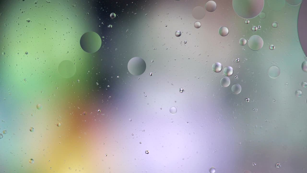 Fantastic structure of colorful bubbles. Chaotic motion. Abstract colorful paint. Top view. Movement of bubbles in the liquid. Oil surface multicolored background. Macro