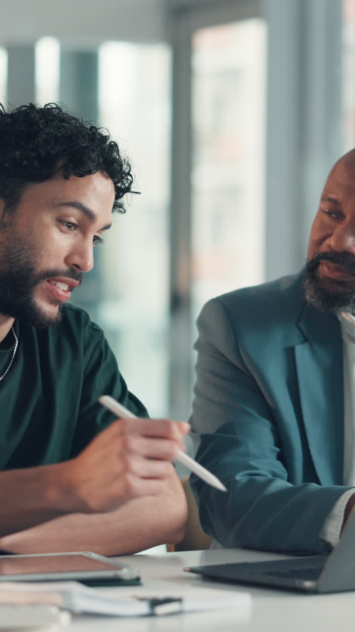 Diversi uomini d'affari che collaborano su un portatile durante una riunione in un ufficio moderno