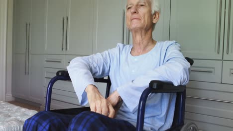 hombre mayor en silla de ruedas saludando en casa