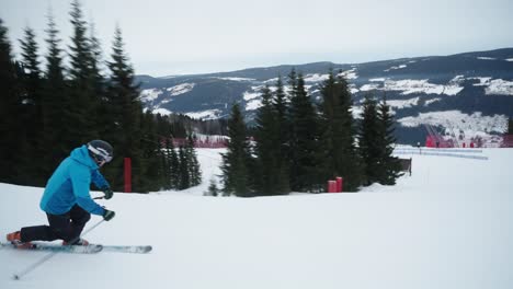 tracking of skilled telemark skier going fast down with small curves the slope on a cloudy winter day in norway