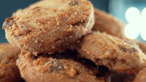 a macro close up cinematic shot of a plate full of crispy juicy chocolate chip cookies, on a rotating stand, studio lighting, super slow motion, 120 fps, full hd video