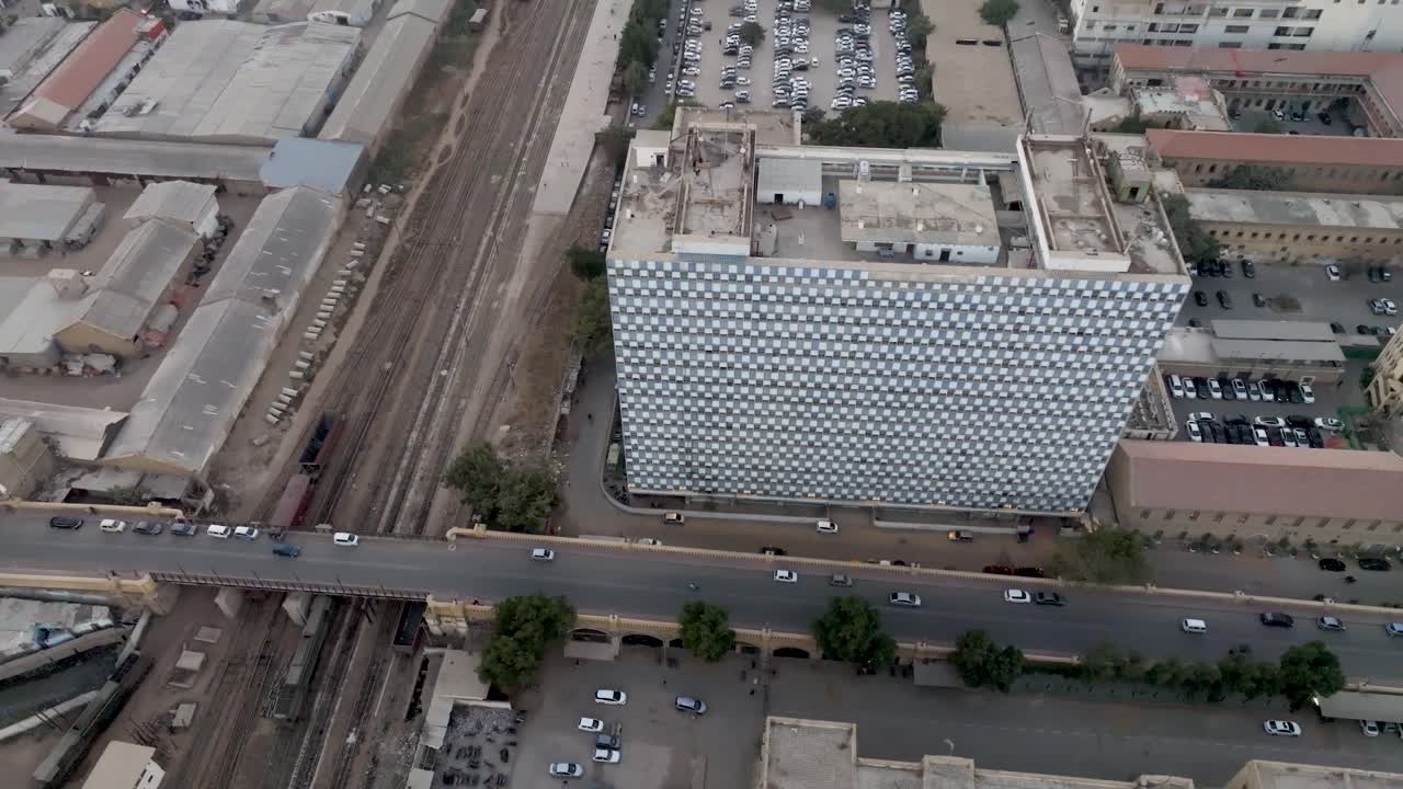 drone aéreo girando disparado sobre un puente que se une a la carretera principal mientras los coches y las bicicletas pasan en karachi, pakistán durante el día
