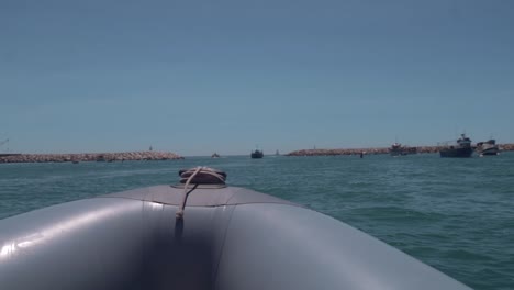 punto de vista en una lancha rápida que navega por el mar con barcos a la distancia