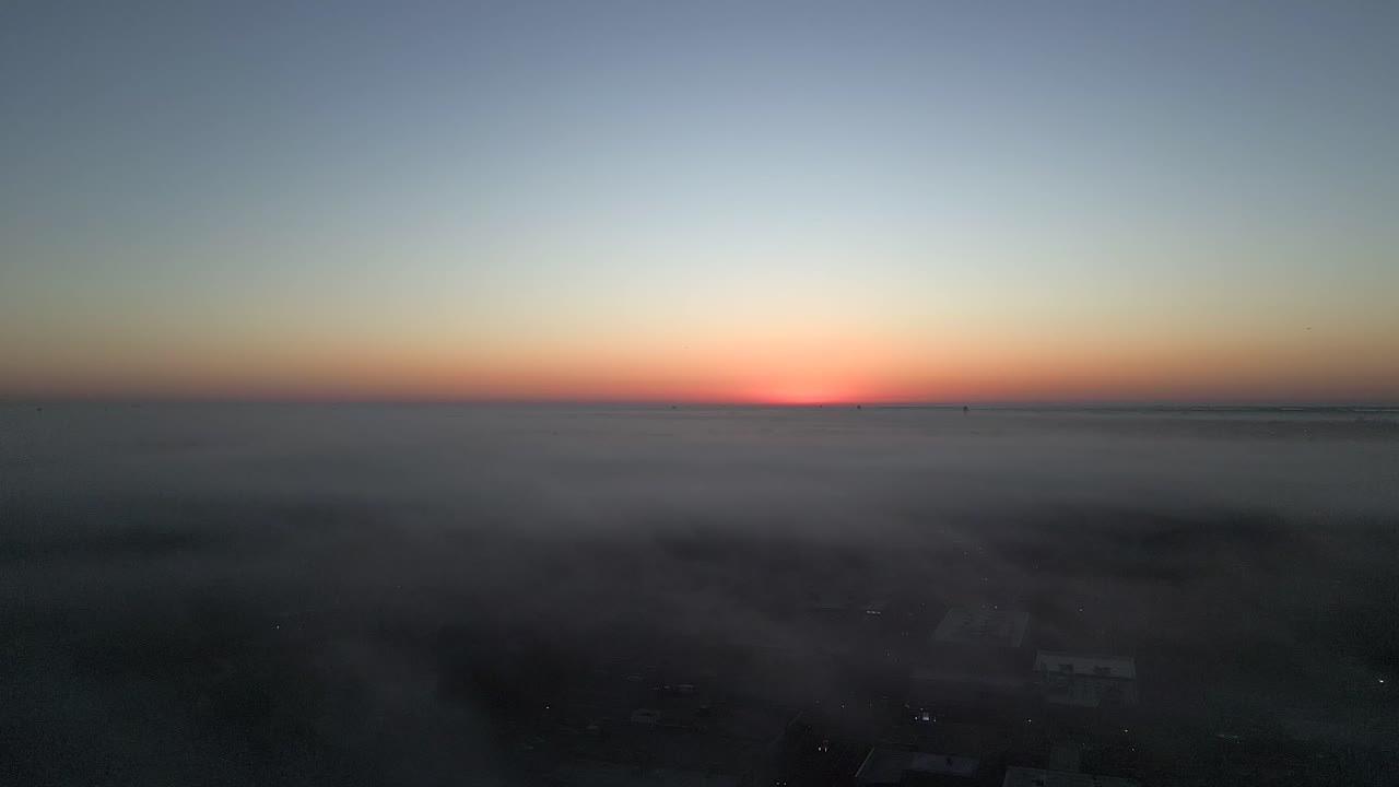 un gran ángulo, vista aérea por encima de la niebla durante un amanecer sobre long island, nueva york