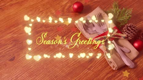 Animation-of-seasons-greetings-text-over-cutlery-at-christmas