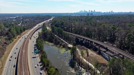 Rural-American-Landscape-with-forest,-rail,-river-and-driving-cars-on-highway