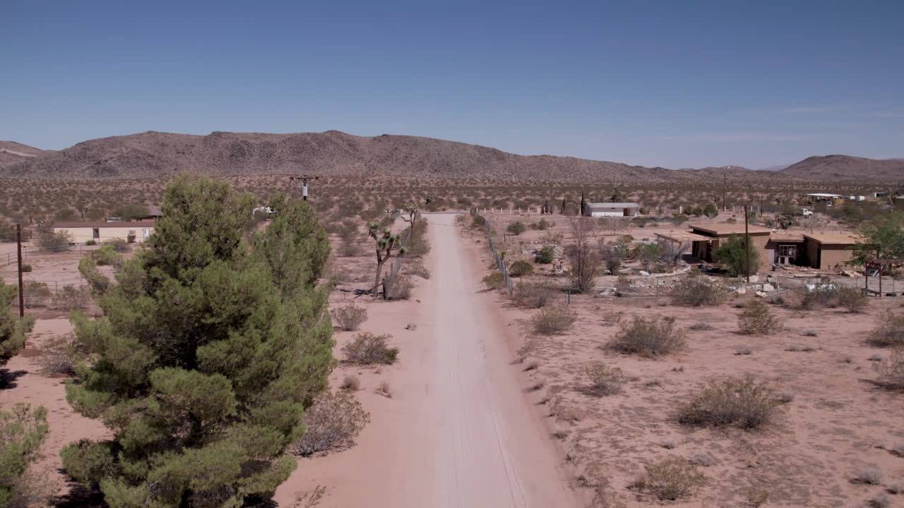 joshua tree california camino de tierra con casas en el desierto-5