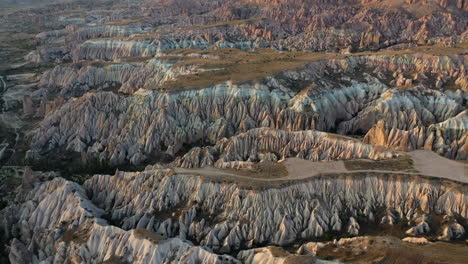 epic cinematic aerial drone shot of the rocky faces of the mountains surrounding cappadocia, turkey