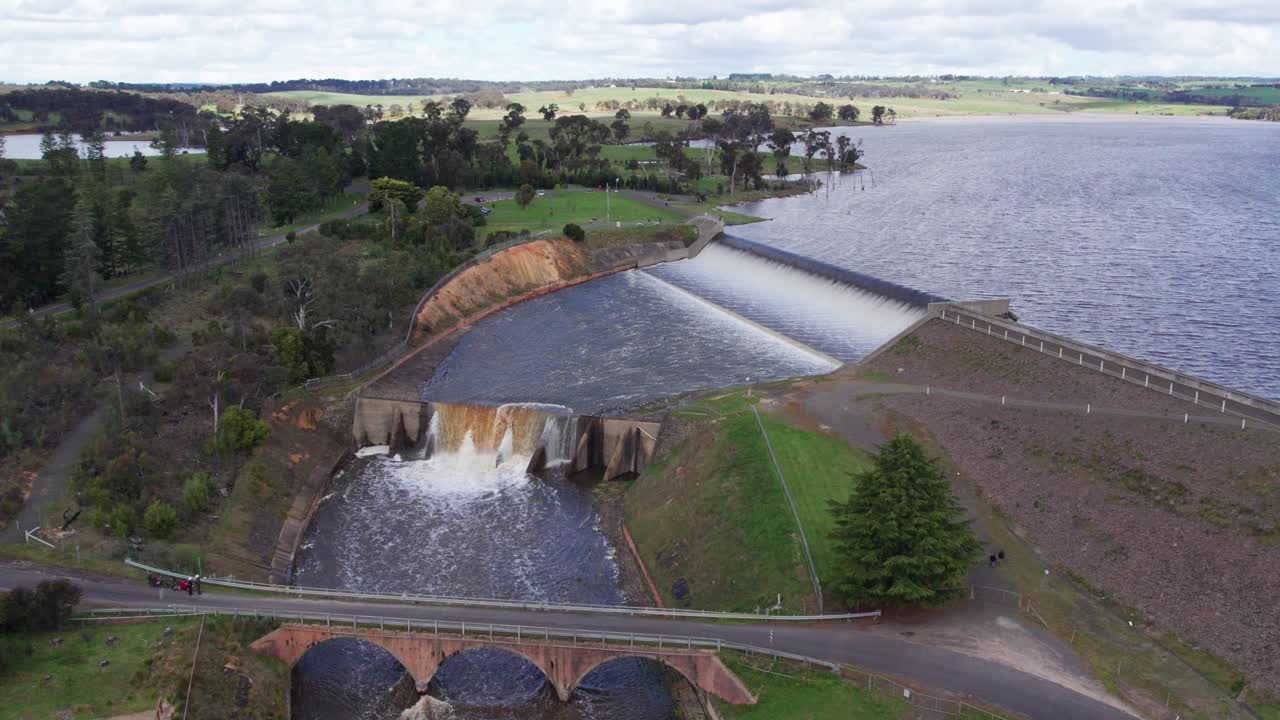 Moving up and away view of water spilling over the Upper Coliban Reservoir spillway, central Victoria, Australia. October, 2022.